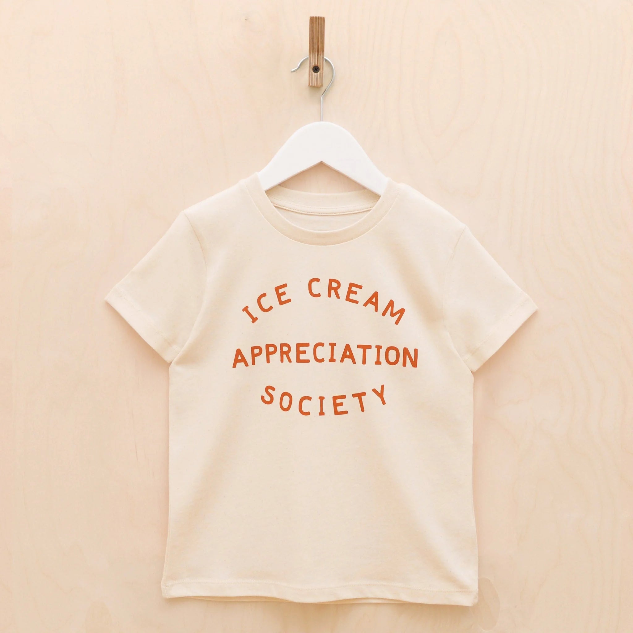 Natural coloured organic cotton t-shirt with "ice cream appreciation slogan printed in rust orange text